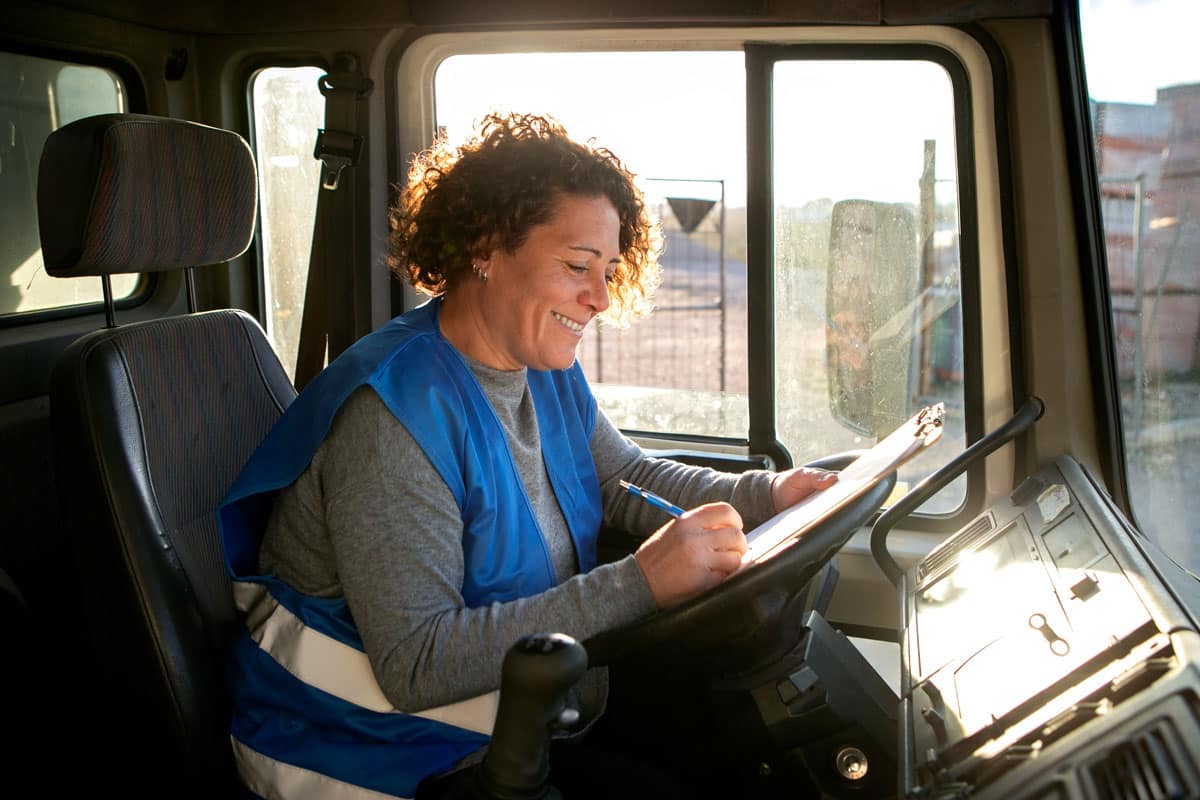 logistics-internal-communications-commskit Older female truck driver (logistics company) filling out a safety communications report for CommsKit