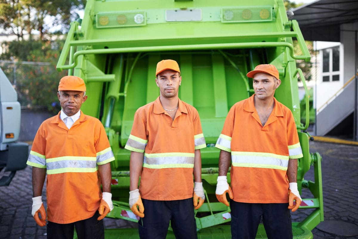 muncipal-public-sector-workers-employee-engagement-commskit Municipal frontline workers (public sector) showing three council workers doing refuse collection standing in front of a garbage truck