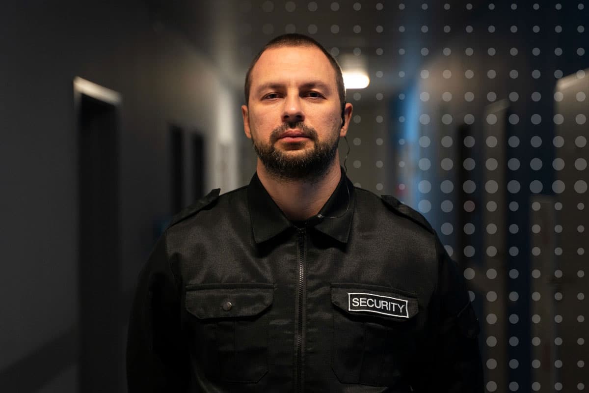 security-defence-frontline-worker-communications-commskit A security worker at a government defence site standing looking at the camera for employee engagement with CommsKit
